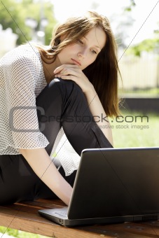 Pretty young woman with a laptop at park