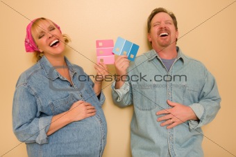 Laughing Man and Pregnant Woman Deciding on Pink or Blue Wall Paint with Swatches in Hand.
