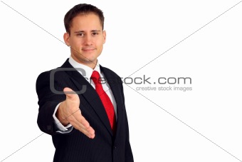 Handsome young man in a suit saying welcome and giving you his hand