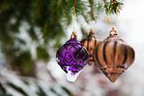 Christmas baubles on a snowy pine