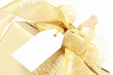 Golden christmas gift box with blank tag 