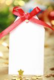 Blank gift tag tied with a bow of red satin ribbon 