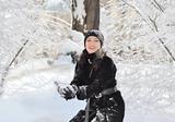 Portrait of cute young woman playing snowball outdoor in winter