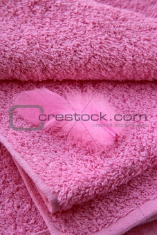 pink towel with a pink featherl spa concept