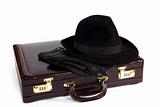 Suitcase with laying from above a hat and gloves