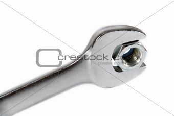 The image of a wrench with a nut, isolated, on a white background