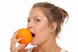 Young woman bites an orange