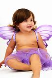 little girl with purple angle wings sitting and smiling