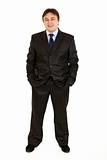 Smiling  businessman keeping his hands in trousers pockets 
