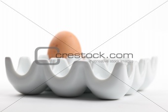 Ceramic egg holder with brown chicken egg
