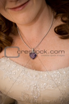 sexy bride showing her purple stoned necklace and cleavage