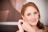 sexy beautiful bride inserting her earrings in whilst smiling