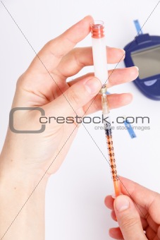 Female hands type in a syringe insulin with Glucose Meter