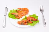 Royal shrimps on leaves of green salad in a white plate