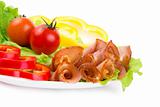Slices of a ham, paprika on leaves of green salad with cherry