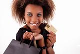 Happy black girl with shopping bags and credit card, isolated on a white background. Studio shot.
