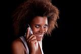 Beautiful black woman happy on the phone, isolated on black background. Studio shot.