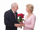 Elderly man giving red roses to elderly woman