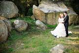 bride and groom hugging standing outside next to rocks