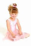 Little girl wearing pink ballet outfit and sit on floor