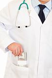 Medical doctor putting  money in pocket robe. Close-up.
