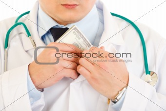 Medical doctor putting  money in pocket. Close-up.
