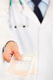 Doctors hand holding medical prescription. Close-up.
