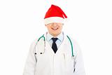 Smiling medical doctor in Christmas hat stretched over his eyes
