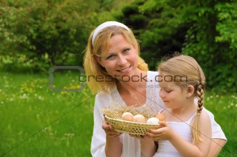 Mother and daughter holding fresh eggs