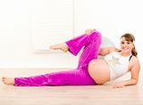 Smiling beautiful pregnant woman doing aerobics exercise  at home
