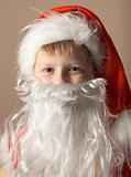 Little boy in Santa Claus suit with beard