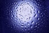 Round water drops on blue background close-up