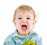 Beautiful baby boy eats green apple.