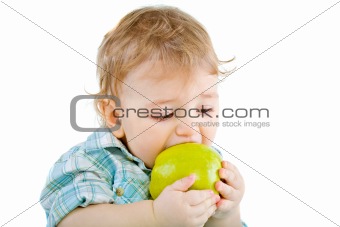 Beautiful baby boy eats green apple.