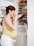 pregnant woman eating sandwich