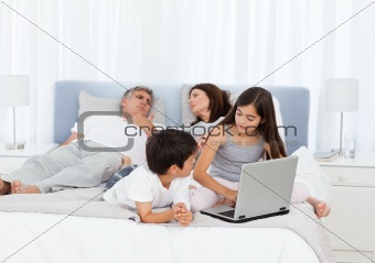 Childrens looking at their laptop while parents are talking