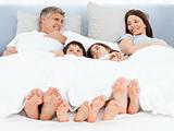 Family lying down in their bed