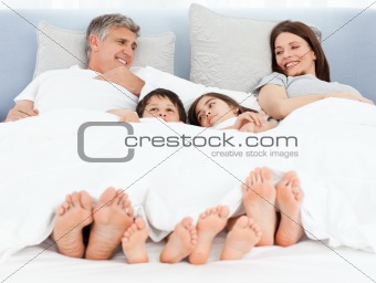Family lying down in their bed