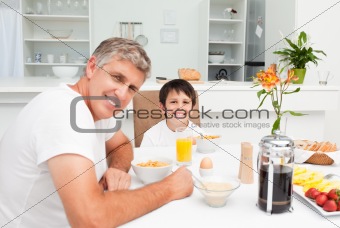 Father having his breakfast with his son
