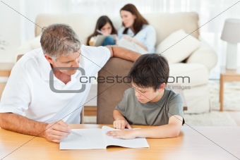 Father helping her son with  his homework 