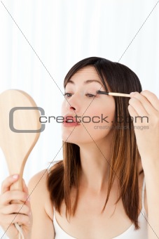 Beautiful woman putting on Make up