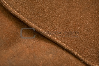 Seam on a brown pressed leather bag
