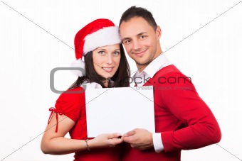 young couple in christmas clothes holding a white cardboard