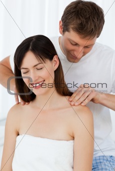 Man giving massage to his wife at home