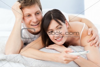 Cute lovers looking at the camera on their bed