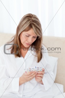 Sick woman taking her pills at home
