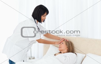Nurse taking the temperature of  her patient