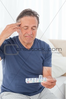 Sick man taking his pills at home