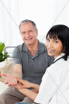 Nurse taking the pulse of  her patient