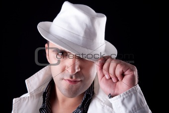 Portrait of a man with his white hat and coat, isolated on black. Studio shot